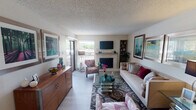 This single-story home at 4927 Wild Holly Ln in Arlington, TX presents a well-organized layout with distinct living spaces connected by an efficient floor plan. The living room serves as the central gathering area, featuring a tiled fireplace as its focal point, light wood-style flooring, a textured ceiling, and a sliding glass door that brings in natural light and provides outdoor access. Built-in shelving flanks the fireplace, offering functional display space.

The kitchen is equipped with dark cabinetry, a mosaic tile backsplash in warm tones, light-colored countertops, a double-basin stainless steel sink, and black appliances. A pass-through window visually connects the kitchen to the dining area, which accommodates a full-sized rectangular dining table with a ceiling fan overhead, creating a practical and comfortable space for meals.

The bedroom offers a calm, neutral atmosphere with carpeted flooring, a ceiling fan, and a walk-in closet providing generous storage. The bathroom includes a tub-shower combination with a curved curtain rod, a speckled vanity countertop, and updated fixtures. Throughout the home, the consistent use of light tones and wood-style flooring contributes to a cohesive and inviting overall ambiance.