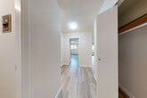 This 1-bedroom, 1-bathroom unit in Surrey, BC is thoughtfully laid out across a single floor, making efficient use of its space. Light-toned hardwood flooring runs throughout, lending a clean, cohesive feel to every room.

The living room is a generous, open area bathed in natural light from a large sliding glass door that opens to a balcony overlooking lush greenery — a standout feature that brings the outdoors in.

The galley-style kitchen is well-appointed with white cabinetry, marble-look countertops, a subway tile backsplash, and a full suite of appliances including a range and refrigerator. Ample upper and lower cabinet storage makes the most of the layout.

The bedroom is a comfortable, well-proportioned room featuring a window with garden views, a dedicated closet, and baseboard heating. Light fills the room, creating a calm and restful atmosphere.

A hallway connects the main living areas and includes built-in closet storage, adding to the unit's practical storage solutions. Textured ceilings are present throughout, and the overall palette of crisp white walls paired with warm flooring creates a bright, welcoming ambiance throughout the home.