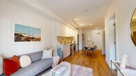 This 410 square foot apartment in Coquitlam, BC, offers a compact yet well-designed living space. The single-floor layout includes one bedroom, a den/office, a living room, a kitchen, and one bathroom. The primary bedroom, measuring 110 square feet, features a large window providing natural light and views of the surrounding greenery.

The kitchen showcases a modern design with sleek white cabinetry, stainless steel appliances, and a functional layout. It opens to a dining area, creating an integrated living space. The living room is bright and airy, with large windows offering outdoor views and access to a patio area.

The apartment's office space is efficiently designed, featuring a built-in desk and ample natural light. The bathroom presents a clean, contemporary aesthetic with a white color scheme and modern fixtures. Throughout the apartment, hardwood flooring adds warmth and continuity.

Storage solutions are incorporated seamlessly, as evidenced by the bedroom's built-in closet. The overall design emphasizes a neutral color palette with occasional pops of color in furnishings and artwork, creating a harmonious and inviting atmosphere in this compact urban dwelling.