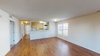 Located at 4300 Collegiate Way in Mount Pleasant, Michigan, this single-floor unit offers a practical and functional layout well-suited for everyday living. The open-concept living area features warm hardwood-style flooring and is filled with natural light from multiple windows, including a glass exterior door that provides views of the surrounding greenery. A half-wall peninsula separates the living space from the kitchen, which is equipped with light wood cabinetry, laminate countertops, a full suite of white appliances including a range, microwave, dishwasher, and refrigerator, and a stainless steel sink positioned beneath a window. The bedrooms are carpeted for comfort and each includes a sliding-door closet with built-in shelving, offering ample storage. Windows in each bedroom bring in natural light and outdoor views. The bathroom features dual sinks set into a light wood vanity with a large wall mirror above, hardwood-style flooring, and a separate water closet housing a full tub-shower combination. Textured ceilings are present throughout the common areas, adding subtle visual interest. The overall layout is efficient and well-organized, making this unit a comfortable and functional living space.