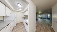 Located in Lynnwood, Washington, this one-bedroom, one-bathroom unit offers a practical and well-organized single-floor layout. The living area features wood-look flooring throughout and is brightened by a ceiling fan with a light fixture, creating a clean and functional space. A sliding glass door allows natural light to filter in and provides access to the exterior. The layout flows seamlessly from the living area into a hallway connecting all rooms.

The galley-style kitchen is efficiently designed with white cabinetry lining both walls, offering ample storage space. Granite-look countertops complement the white appliances, which include an electric range, oven, and refrigerator, along with a stainless steel sink — providing all essential cooking amenities in a compact, organized footprint.

The bedroom is carpeted for comfort and features a window with views of surrounding greenery, filling the room with natural light. A sliding double-door closet provides convenient storage, and the room offers enough space for standard bedroom furnishings.

The bathroom is clean and bright, appointed with white fixtures including a tub-shower combination with a curved curtain rod, a vanity with a marble-look countertop and under-sink storage, and wood-look flooring that ties the space together cohesively with the rest of the unit.
