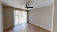 This single-floor residence offers a thoughtfully designed layout with consistent, modern finishes throughout. Durable hardwood-style flooring flows seamlessly across the living, dining, and bedroom areas, lending a cohesive and clean aesthetic to the entire space.

The open-concept living area is bright and airy, featuring a ceiling fan with integrated lighting and a sliding glass door fitted with vertical blinds that opens to a private outdoor area, allowing natural light to fill the room.

The kitchen is a functional standout, outfitted with dark espresso cabinetry, granite-style countertops, and a full suite of stainless steel appliances including a refrigerator, electric range, and built-in microwave. A raised breakfast bar provides a natural boundary between the kitchen and the living space, making it ideal for casual dining or entertaining. A window above the sink adds additional natural light to the kitchen.

The bedroom is generously sized, equipped with a ceiling fan and a window with blinds. A doorway leads to a walk-in closet with built-in shelving, offering practical and ample storage.

The bathroom features a full tub-shower combination, granite-topped vanity, and light wood-style flooring that complements the rest of the home. Clean, neutral wall tones throughout the residence create a calm and inviting atmosphere.