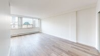 Located on the 10th floor at 484 Avenue Rd in Toronto's prestigious Avenue Road corridor, this 3-bedroom, 1-bathroom unit offers a clean, modern living experience with city views. The open-concept layout is unified by light hardwood flooring throughout, creating a bright and cohesive feel across the living spaces.

The kitchen is thoughtfully designed with white cabinetry, sleek bar-pull hardware, a white tile backsplash, light countertops, a double stainless steel sink, and stainless steel appliances — including a refrigerator and range. Light tile flooring completes the kitchen's crisp, contemporary aesthetic.

The generously sized primary bedroom is the largest of the three rooms, offering ample space and a sliding mirrored closet door that adds both functionality and depth. The additional bedrooms also feature hardwood floors and large windows that frame views of the surrounding Toronto skyline and greenery, filling each room with natural light.

The bathroom features full-surround marble-effect ceramic tile, a soaker tub, and clean chrome fixtures, providing a calm and polished finish. A hallway connects the rooms efficiently, contributing to the unit's practical flow.

Throughout the unit, large windows and baseboard heating underscore the elevated, comfortable living environment this well-appointed Toronto address provides.