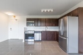 Located at 4979 Bathurst St in Toronto's North York neighbourhood, this two-bedroom, one-bathroom unit offers a practical and well-appointed layout across a single floor. The open-concept kitchen and living area form the heart of the unit, featuring rich dark-wood cabinetry, a white subway tile backsplash, stainless steel appliances including a refrigerator, stove, dishwasher, and built-in microwave, and clean tile flooring that transitions into polished parquet hardwood throughout the living space. Natural light flows in through a large picture window in the living area, offering pleasant views of the surrounding tree canopy. Both bedrooms are comfortably proportioned, each with parquet hardwood floors, individual windows with greenery views, and baseboard heating units. The primary bedroom includes a mirrored sliding closet, adding both storage and a sense of depth to the room. The bathroom is finished with large-format beige tiles surrounding a soaker tub and shower combination with chrome fixtures. A dedicated closet provides additional storage. The unit's clean, neutral palette and functional design make it a well-suited residence in this established Toronto neighbourhood.