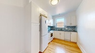 Located on Avenue des Decelles in Montréal's Côte-des-Neiges–Notre-Dame-de-Grâce borough, this well-appointed 2-bedroom, 1-bathroom unit offers a comfortable and functional single-floor layout. Warm hardwood flooring flows throughout every room, creating a cohesive and inviting atmosphere.

The living room is generously sized, bathed in natural light from large windows, and provides direct access to a private balcony overlooking lush, mature trees. A radiator ensures efficient heating during Montréal's winters. The second living area is equally spacious with clean white walls and ample room for flexible use.

The kitchen is thoughtfully designed with white shaker-style cabinetry, grey countertops, a striking blue-and-white mosaic tile backsplash, and white appliances including a stove, microwave, refrigerator, and dishwasher. A window above the sink brings in natural light.

The primary bedroom is a well-proportioned retreat featuring a large window with outdoor views and a radiator. The second bedroom is cozy and bright with its own window. A welcoming hallway connects the rooms throughout the unit.

The bathroom is finished in crisp white tile, featuring a full bathtub, toilet, vanity with storage, and a window for natural ventilation. The overall aesthetic is clean, bright, and move-in ready.