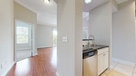 This thoughtfully designed 2-bedroom, 3-bathroom residence offers a comfortable and functional single-floor layout. The open-concept living area is anchored by rich hardwood flooring and neutral tones, creating a bright and welcoming atmosphere. Crown molding accents the living and dining spaces, adding a refined architectural touch. An elegant arched passageway connects the living area to the kitchen, which is equipped with stainless steel appliances, granite countertops, white cabinetry, and tile flooring — offering both style and practicality.

Both bedrooms are carpeted for comfort and feature large windows with horizontal blinds that invite natural light and outdoor views of surrounding greenery. The primary bedroom connects to a dedicated bathroom and a walk-in closet with wire shelving systems for organized storage. The bathrooms are finished with tile flooring, granite countertops, white cabinetry, and well-lit vanity mirrors. One bathroom features a soaking tub framed by tile surround, adding a spa-like quality to the space.

Overall, the residence presents a clean, neutral palette throughout, with consistent attention to finish quality, making it a functional and comfortable home.