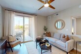 Located at 28851 N Vistancia Blvd in Peoria, AZ, this 2-bedroom, 2-bathroom residence offers a thoughtfully designed single-floor layout. The open-concept living area features light wood-style flooring, neutral tones, and a ceiling fan, creating a bright and welcoming atmosphere. Sliding glass doors connect the living room to a private patio, ideal for enjoying Arizona's sunny climate. The kitchen is a standout, boasting white cabinetry, subway tile backsplash, granite countertops, stainless steel appliances, and a peninsula island with bar seating and pendant lighting overhead. Both bathrooms are finished with granite vanity tops, white cabinetry, and tub-shower combinations with classic white tile surrounds. The spacious primary bedroom includes a ceiling fan, wood-style flooring, and direct access to a walk-in closet and en-suite bath. The second bedroom is equally comfortable with its own closet. Additional conveniences include a dedicated in-unit laundry area with a full-size washer, a utility room, and a hallway connecting all spaces efficiently. The overall ambiance is modern, clean, and designed for comfortable everyday living.