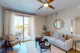 Located at 28851 N Vistancia Blvd in Peoria, AZ, this 2-bedroom, 2-bathroom residence offers a thoughtfully designed single-floor layout. The open-concept living area features light wood-style flooring, neutral tones, and a ceiling fan, creating a bright and welcoming atmosphere. Sliding glass doors connect the living room to a private patio, ideal for enjoying Arizona's sunny climate. The kitchen is a standout, boasting white cabinetry, subway tile backsplash, granite countertops, stainless steel appliances, and a peninsula island with bar seating and pendant lighting overhead. Both bathrooms are finished with granite vanity tops, white cabinetry, and tub-shower combinations with classic white tile surrounds. The spacious primary bedroom includes a ceiling fan, wood-style flooring, and direct access to a walk-in closet and en-suite bath. The second bedroom is equally comfortable with its own closet. Additional conveniences include a dedicated in-unit laundry area with a full-size washer, a utility room, and a hallway connecting all spaces efficiently. The overall ambiance is modern, clean, and designed for comfortable everyday living.