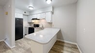 Located at 2912 Chimney Rock Dr in Nacogdoches, TX, this one-bedroom, one-bathroom unit offers a well-organized, single-floor layout designed to maximize every square foot. The kitchen is a standout feature, boasting crisp white cabinetry, light speckled countertops, a black gas range, dishwasher, and a built-in peninsula that doubles as a breakfast bar or prep space. Wood-look flooring runs throughout the unit, providing a cohesive and easy-to-maintain surface across all rooms. The living area benefits from natural light filtering in through windows, visible in the doll-house view, and a ceiling fan adds both style and comfort. The bedroom is a comfortable, well-proportioned space with its own ceiling fan, a window overlooking the greenery outside, and direct access to both a dedicated closet and the full bathroom — offering a practical and private layout. The bathroom features a full tub and shower combination with clean white surroundings and brushed nickel fixtures. Neutral gray and beige wall tones throughout the unit create a calm, versatile backdrop suitable for a variety of décor styles. This unit presents a functional and tidy living space well-suited for individuals or couples seeking simplicity and convenience in Nacogdoches.