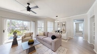Located at 7101 Chase Oaks Boulevard in Plano, TX, this thoughtfully designed 2-bedroom, 3-bathroom residence offers a seamless blend of comfort and modern style across a single level. The open-concept living area is anchored by herringbone-patterned light wood flooring, crown molding, and a ceiling fan, while large sliding glass doors and windows flood the space with natural light and provide views of the surrounding greenery. The living and dining areas flow naturally into one another, creating an inviting, airy atmosphere. The kitchen features white shaker cabinetry with matte black hardware, stainless steel appliances, light quartz countertops, a subway tile backsplash, and a breakfast bar peninsula. The spacious primary bedroom includes plush carpeting, a bold accent wall, a large window, and access to a walk-in closet outfitted with wire shelving. The primary bathroom is finished with white dual-vanity cabinetry, black hardware accents, a large mirror, and a tub-shower combo. The second bedroom offers generous closet space with dual panel doors and its own ceiling fan. An in-unit laundry room provides added convenience, and the hallway connects all spaces efficiently. The overall aesthetic is clean, contemporary, and move-in ready.