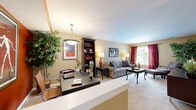 This one-bedroom, one-bathroom residence in Bloomingdale, Illinois offers a well-organized layout that makes efficient use of its space. The open-concept living and dining area is bright and inviting, with plush carpeting, warm neutral walls, and a large window dressed in rich burgundy curtains that allow ample natural light. A tall bookcase adds character to the living room, which flows seamlessly into the dining area. The dining space features light hardwood-style flooring and a sliding glass door that opens to an outdoor view, flooding the room with daylight. The kitchen is efficiently appointed with a gas range, over-the-range microwave, and light wood cabinetry paired with white appliances, providing all the essentials in a compact, functional footprint. The generously sized bedroom features a bold accent wall, soft carpeting, and a walk-in closet, offering ample storage. A second window brings in additional natural light and outdoor views. The bathroom includes a vanity with light wood cabinetry, a well-lit mirror, and tile flooring, maintaining the clean aesthetic found throughout the home. A dedicated office nook with an accent wall and pendant lighting rounds out this versatile and comfortable residence.