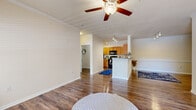Located at 105 Churchill Falls Dr in Duncan, SC, this well-appointed 2-bedroom, 3-bathroom residence offers a thoughtfully designed single-floor layout that balances comfort and functionality. The living room is bright and welcoming, featuring rich hardwood-style flooring, crown molding, a ceiling fan, and large windows that invite natural light, along with a rear door providing outdoor access. The kitchen connects seamlessly to the living area via a peninsula breakfast bar with a dark stone-style countertop and overhead track lighting, making it ideal for both everyday living and entertaining. Each bedroom is carpeted for warmth and comfort, with ample natural light from large windows fitted with blinds. The generously sized primary bedroom includes a walk-in closet outfitted with multi-tier wire shelving for organized storage. The bathrooms are finished with warm wood-toned cabinetry and hardwood-style flooring; one features a soaking tub, while another includes a tub-shower combination. A dedicated laundry room with hardwood-style flooring, wire shelving, and washer/dryer hookups adds everyday convenience. Throughout, neutral tones and clean finishes create a cohesive and inviting atmosphere.