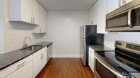 This contemporary 850 square foot apartment in Philadelphia offers a well-designed living space with two bedrooms and one bathroom. The interior showcases a harmonious blend of functionality and aesthetic appeal, featuring sleek hardwood flooring throughout. The primary bedroom, generously sized at 200 square feet, provides ample space for relaxation and storage.

The kitchen is efficiently designed with modern appliances, including a stainless steel refrigerator and range, complemented by crisp white cabinetry and contrasting dark countertops. The bathroom boasts a clean, minimalist design with a combination tub-shower unit and ample vanity space.

Large windows in the living areas and bedrooms allow for abundant natural light, creating a bright and airy atmosphere. The apartment's open-concept layout seamlessly connects the kitchen and living spaces, ideal for entertaining or everyday living. A standout feature is the walk-in closet, offering excellent storage solutions.

The property's location at 3131 Walnut St places residents in the heart of Philadelphia, providing easy access to urban amenities. This apartment combines modern comfort with practical urban living, making it an attractive option for those seeking a contemporary home in a vibrant city setting.