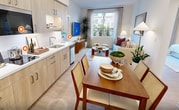 This efficiently designed 720-square-foot, single-floor unit offers 3 bedrooms and 2 bathrooms with a bright, modern aesthetic throughout. Light wood-tone flooring and crisp white walls create a clean, cohesive look across all rooms. The kitchen is outfitted with natural wood cabinetry, white countertops, stainless steel appliances including a bottom-freezer refrigerator, a built-in microwave, dishwasher, and a double sink — all complemented by recessed lighting and an adjacent dining area. The living room features a large window overlooking lush greenery and palm trees, filling the space with natural light. The primary bedroom spans 130 square feet and connects to a hallway leading toward the kitchen and common areas. All three bedrooms include large windows with garden and building views, providing ample natural light. The two bathrooms are finished with light wood vanities, white countertops, wood-tone flooring, and large mirrors. One bathroom includes a glass-enclosed walk-in shower with white subway tile and built-in open shelving. A closet and two hallways complete the layout, offering practical storage and circulation throughout this well-appointed unit.