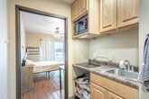 Located at 1518 N Peach Ave in Marshfield, Wisconsin, this efficient one-bedroom, one-bathroom unit is thoughtfully designed to make the most of its compact footprint. Warm hardwood flooring runs throughout, lending a cohesive and inviting feel to the entire space.

The bedroom is the largest room in the unit, comfortably accommodating a full-sized bed and additional furnishings. A ceiling fan with light fixture provides both airflow and overhead lighting, while a window with grommet-style curtains allows natural light to filter in and offers views of the surrounding area. A closet provides dedicated storage within the unit.

The kitchenette, accessible via a short hallway, is efficiently outfitted with light oak cabinetry above and below the counter, a built-in microwave, a smooth-top electric cooktop, and a stainless steel sink — offering all the essentials for everyday meal preparation within a compact footprint.

The bathroom continues the warm wood-toned aesthetic with matching oak cabinetry above the toilet for additional storage. A tub-shower combination with a curtain, toilet, and wood-look flooring complete the space. The hallway connecting the rooms also provides access to the closet, keeping the overall layout organized and easy to navigate.

This unit is a practical and straightforward living space suited for those seeking simplicity and efficiency in Marshfield, WI.