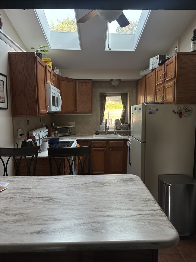 kitchen with peninsula, dishwasher, microwave, fridge, oven, electric stove, water filter - 112 W 1st Ave