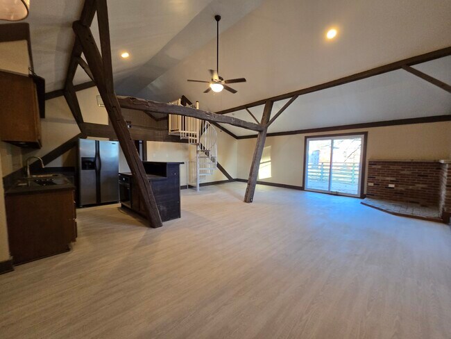 Spacious living room with vaulted ceilings and exposed beams. - 60 W Winter St