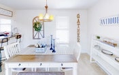Located at 5840 Lake Resort Terrace in Chattanooga, Tennessee, this two-floor residence offers a warm, farmhouse-inspired aesthetic throughout its thoughtfully designed layout. The living room serves as a welcoming gathering space, featuring plush carpeting, a ceiling fan, and charming wall décor. The dining area is highlighted by a stylish chandelier, a farmhouse-style table with white chairs, and a window that brings in natural light. The kitchen is well-appointed with white cabinetry, dark granite-style countertops, a stainless steel sink, and black appliances, complemented by wood-look flooring for a clean, functional workspace. The primary bedroom offers a comfortable retreat with carpeted floors and a textured ceiling, while a secondary bedroom provides a cozy guest space complete with louvered closet doors. The bathrooms feature granite-style countertops and a shower-tub combination with a colorful curtain. Hallways are lined with louvered storage closets, adding practical storage throughout. The overall ambiance of the home is cozy and character-filled, with consistent neutral tones and rustic accents that create a cohesive and inviting living environment across both floors.