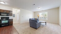 Located at 324 N Emporia Ave in Wichita, Kansas, this one-bedroom, one-bathroom unit offers a well-organized and functional single-floor layout. The living room is a comfortable, open space finished with plush wall-to-wall carpeting and neutral wall tones that create a bright, welcoming atmosphere. A large window allows natural light to fill the room, offering views of surrounding greenery. The kitchen is thoughtfully designed with rich dark wood cabinetry, a classic white subway tile backsplash, wood-look flooring, and a full suite of black appliances including a refrigerator, dishwasher, and range. A louvered closet door near the entryway provides convenient storage. The bedroom is a well-proportioned retreat, also carpeted, featuring multiple windows with natural light and a walk-in closet. The bathroom continues the warm wood-look flooring found throughout the wet areas and includes a shower-tub combination. A dedicated laundry area houses a stacked full-size washer and dryer unit, adding everyday convenience. Clean lines, consistent finishes, and a practical layout make this space an efficient and comfortable home in the heart of Wichita.