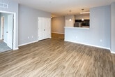 Located at 651 Rain Forest Rd in Knoxville, TN, this single-floor unit offers a well-designed, open-concept layout with a cohesive modern aesthetic. The living area features warm wood-look luxury vinyl plank flooring and neutral gray walls, creating a bright and welcoming atmosphere. Natural light filters in through windows fitted with blinds, enhancing the sense of openness throughout.

The kitchen is a standout feature, equipped with dark espresso cabinetry, white quartz countertops, and stainless steel appliances including a refrigerator, electric range, microwave, and dishwasher. A peninsula with pendant lighting separates the kitchen from the living space, making it ideal for everyday functionality and entertaining. The galley-style kitchen layout maximizes counter and storage space efficiently.

The bedrooms are carpeted for comfort and each include a ceiling fan with light fixture and windows that allow natural light. The bathrooms feature the same dark cabinetry as the kitchen, paired with white countertops, large mirrors, and wood-look flooring for a consistent design language. A hallway with multiple entry points connects the various rooms, providing a practical and logical flow throughout the unit. The overall design is clean, contemporary, and move-in ready.