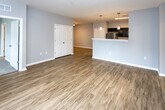 Located at 651 Rain Forest Rd in Knoxville, TN, this single-floor unit offers a well-designed, open-concept layout with a cohesive modern aesthetic. The living area features warm wood-look luxury vinyl plank flooring and neutral gray walls, creating a bright and welcoming atmosphere. Natural light filters in through windows fitted with blinds, enhancing the sense of openness throughout.

The kitchen is a standout feature, equipped with dark espresso cabinetry, white quartz countertops, and stainless steel appliances including a refrigerator, electric range, microwave, and dishwasher. A peninsula with pendant lighting separates the kitchen from the living space, making it ideal for everyday functionality and entertaining. The galley-style kitchen layout maximizes counter and storage space efficiently.

The bedrooms are carpeted for comfort and each include a ceiling fan with light fixture and windows that allow natural light. The bathrooms feature the same dark cabinetry as the kitchen, paired with white countertops, large mirrors, and wood-look flooring for a consistent design language. A hallway with multiple entry points connects the various rooms, providing a practical and logical flow throughout the unit. The overall design is clean, contemporary, and move-in ready.