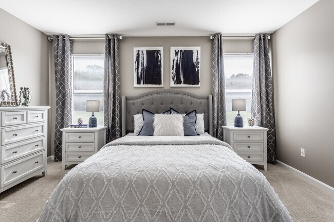 Ingrese a un dormitorio sereno lleno de luz natural y un diseño cuidado, que ofrece un espacio cómodo y funcional para relajarse. - Wheaton Village Apartments