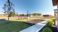 Located at 6249 Walton Breck Way in Westerville, Ohio, this single-floor commercial space is part of a modern mixed-use development identifiable by its "HQ" signage visible from the street. The exterior presents a polished, professional appearance, framed by freshly landscaped grounds, newly planted trees, manicured green lawns, and a clean concrete walkway — all set beneath an open sky with views of the surrounding Westerville neighborhood.

The interior, captured under low-light conditions, reveals a compact yet purposefully designed layout. Subtle ambient lighting, including distinctive green LED accent strips along the floor, lends the space a contemporary and atmospheric quality. The low-profile lighting design suggests a deliberate aesthetic choice, contributing to a sleek, modern ambiance. Interior rooms appear to feature smooth wall surfaces, defined spatial separations, and minimal detailing — characteristics consistent with a professional or office-oriented environment.

The single-floor layout offers straightforward navigation and accessibility throughout. The overall character of the space — from its well-kept exterior setting to its understated, modern interior — positions it as a functional and visually refined commercial destination within the Westerville community.