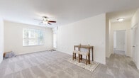 Located at 4229 Stonecrest Dr in Burlington, NC, this single-story, 2-bedroom, 2-bathroom home offers a thoughtfully organized layout designed for comfortable everyday living. The open living room features neutral-toned carpet, a ceiling fan with light fixture, and multiple windows fitted with blinds that allow ample natural light to fill the space, creating a bright and airy atmosphere.

The galley-style kitchen is well-appointed with warm honey-toned cabinetry, granite-look countertops, a double stainless steel sink, and black appliances including an electric range, built-in microwave, and dishwasher. Wood-look flooring ties the kitchen together with a clean, practical finish.

The generously sized primary bedroom offers plush carpeting, a ceiling fan, and a walk-in closet equipped with wire shelving for ample storage. The second bedroom mirrors the same comfortable, carpeted design with natural light from a window. Both bathrooms feature warm wood vanities, white countertops, and large mirrors.

A dedicated laundry room comes ready with washer and dryer hookups, adding functional convenience. The home is completed by a walk-in closet with full wire shelving systems, ensuring storage is never a concern. The overall palette of soft whites and warm neutrals gives the home a clean, welcoming feel throughout.
