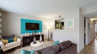 Located at 3751 Appian Way in Lexington, Kentucky, this single-floor residence offers a well-designed layout that balances style and functionality. The living room serves as the heart of the space, highlighted by a bold teal accent wall that anchors the entertainment area. Light wood-style flooring runs throughout, complementing the neutral palette, while large windows dressed with patterned curtains invite an abundance of natural light and create a warm, inviting atmosphere. A pass-through window connects the living area to the kitchen, enhancing the open feel of the space.

The kitchen is thoughtfully appointed with rich, dark cabinetry, granite-style countertops, stainless steel appliances, and light wood-style flooring, offering both practicality and a sleek aesthetic. The bedroom features plush carpeting, a vibrant yellow accent wall, and generous natural light from a large window with blinds. A bi-fold door closet provides ample storage space. The full bathroom is finished with dark vanity cabinetry, granite-style countertops, wood-style flooring, and a tub-shower combination, delivering a cohesive and polished look. Throughout the unit, a consistent color scheme of teal, yellow, and neutral tones ties each room together seamlessly.