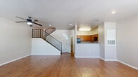 Located at 4649 Loma del Sur Dr in El Paso, TX, this two-story, 2-bedroom, 2-bathroom home offers a well-organized layout across two floors. The main level features an open-concept living, dining, and kitchen area finished with warm wood-look flooring throughout. A ceiling fan anchors the living room, which flows seamlessly toward a staircase with decorative iron railings leading to the upper level. The kitchen is designed in a U-shape with abundant warm-toned wood cabinetry, granite-style countertops, black appliances including an electric range and built-in microwave, and a breakfast bar that connects to the dining and living areas. A dedicated laundry room with washer and dryer hookups is conveniently located on the main floor. Upstairs, both bedrooms are carpeted and feature ceiling fans, natural light from windows with views of surrounding trees, and ample closet space — three closets are distributed throughout the home. The primary bedroom offers a comfortable footprint with its own dedicated bathroom. A second full bathroom serves the remaining bedroom and guests, one featuring a tub/shower combo and the other a walk-in shower. Clean neutral tones and consistent finishes create a cohesive, move-in-ready atmosphere throughout.