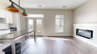 This contemporary apartment in Louisville, Kentucky, offers a harmonious blend of style and functionality. The kitchen is a standout feature, boasting crisp white cabinetry, subway tile backsplash, and stainless steel appliances. A unique kitchen island with metal legs provides additional workspace and casual dining.

The bathroom exudes a spa-like atmosphere with its clean lines, white vanity, and large mirror. Wood-like flooring extends throughout the living areas, creating a warm and cohesive look. Large windows in the bedrooms flood the spaces with natural light, while plush carpeting adds comfort underfoot.

The open floor plan, as seen in the 3D model, allows for easy flow between living spaces. Track lighting in the kitchen area adds a modern touch and provides task lighting. The apartment also includes practical features such as a ceiling fan and a water heater closet.

Overall, this apartment combines modern aesthetics with practical amenities, creating an inviting living space in the heart of Louisville. The neutral color palette and abundance of natural light contribute to a bright, airy atmosphere throughout.