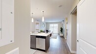 Located on Green Diamond Road in Regina, Saskatchewan, this 2-bedroom, 2-bathroom unit offers a thoughtfully designed single-floor layout that maximizes functionality and comfort. The open-concept living and kitchen area serves as the heart of the home, where light wood-tone flooring flows throughout. The kitchen is equipped with stainless steel appliances — including a refrigerator, stove, and built-in microwave — complemented by crisp white cabinetry, a white quartz countertop, and a navy blue island with bar seating for three, illuminated by sleek pendant lighting. The living area is bright and welcoming, featuring sliding patio doors that invite natural light and provide outdoor access, along with a wall-mounted air conditioning unit. The primary bedroom is a comfortable retreat with a large window fitted with zebra blinds and generous proportions, while the second bedroom offers a cozy, well-lit space with similar window treatments. A dedicated walk-in closet with wire shelving provides ample storage. Both bathrooms are clean and functional, each featuring a full soaker tub with shower combination. The unit presents a modern, neutral palette throughout, making it a practical and inviting living space.