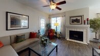 This single-floor residence offers a thoughtfully designed layout that balances comfort and functionality. The living room serves as the heart of the home, featuring warm wood-look flooring, a ceiling fan with light fixture, large windows that invite abundant natural light, and a tiled fireplace that adds a cozy focal point to the space. The room provides ample space for relaxed seating arrangements.

Adjacent to the living area, the dining space is bright and welcoming, highlighted by a pendant chandelier and generous window views. It connects seamlessly to the kitchen, which is outfitted with light wood cabinetry, granite-style countertops, a full suite of appliances including an electric range, built-in microwave, and dishwasher, plus a convenient peninsula that defines the transition between spaces. A skylight overhead adds an extra layer of natural brightness to the kitchen.

The bedroom is a serene retreat with plush carpeting, a ceiling fan, built-in closet storage, and a sliding glass door leading to a private outdoor area. The bathroom features a wide vanity with granite-style countertops, light wood cabinetry, a large mirror, full tub with shower, and wood-look flooring, creating a clean and practical space. Throughout, neutral tones and consistent finishes contribute to a cohesive and inviting atmosphere.