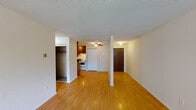 Located at 1164 Mackubin St in Saint Paul, Minnesota, this single-floor unit offers a practical and comfortable layout. The living area features warm hardwood-style flooring that reflects natural light streaming in through a large window fitted with vertical blinds. A textured ceiling and baseboard heating add to the functional character of the space. The open layout connects the living area to a galley-style kitchen, which is equipped with warm wood cabinetry, dark granite-style countertops, a double sink, a white electric range, and a full-size refrigerator. Louvered bifold doors provide convenient access to an adjacent closet or pantry area. The bedrooms are carpeted for added comfort, each featuring ceiling fans, vertical blinds, and baseboard heating. One bedroom also includes a wall-mounted air conditioning unit and windows on two walls, allowing for ample natural light and ventilation. The bathroom is finished with classic mosaic tile flooring, a full tub-shower combination, a vanity with wood cabinetry, and a toilet — all in a clean, straightforward layout. A dedicated closet off the main living area provides additional storage. The overall design is clean and functional, offering a well-organized living environment in a convenient Saint Paul location.