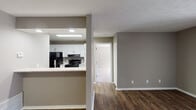 Located at 1081 Garden Walk Blvd in College Park, GA, this single-story unit offers a practical and well-appointed layout with a neutral color palette of warm taupe and crisp white throughout. The open-concept living and dining areas are finished with rich, dark wood-look flooring that extends seamlessly into the kitchen, creating a cohesive and inviting atmosphere. A ceiling fan with a window in the dining area allows natural light to pour in, brightening the connected living space.

The kitchen is designed for functionality, featuring white cabinetry, light granite-style countertops, a mosaic tile backsplash, and black appliances including a refrigerator, electric range, and dishwasher. A pass-through breakfast bar connects the kitchen to the main living area, enhancing the open flow of the space.

Bedrooms are carpeted for comfort, with one featuring a closet and direct access to a private bathroom. Additional bedrooms offer generous natural light through large windows with blinds. The bathroom includes a white vanity with granite-style countertops, a tub-shower combination, and wood-look flooring. Textured ceilings are present throughout, adding a classic finishing detail to the overall design.
