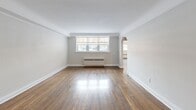 This 2-bedroom, 1-bathroom unit at 120 St Paul Ave in Brantford, Ontario offers a practical and well-laid-out single-floor living space. The living room is a highlight, featuring rich, polished hardwood floors that reflect natural light streaming in through a set of front-facing windows. A charming arched doorway adds a classic architectural touch, connecting the living area to the rest of the unit. Radiator heating is present throughout, ensuring warmth during colder months. The kitchen is efficiently designed with white cabinetry, a subway tile backsplash, light tile flooring, and a full suite of stainless steel appliances including a range, microwave, dishwasher, and refrigerator. A window above the sink brings in natural light. Both bedrooms are finished with light-toned laminate flooring and neutral walls, creating calm and versatile spaces. The primary bedroom offers a comfortable footprint with a window and access to a closet. The bathroom features a clean, white-tiled tub-shower combination with a window for ventilation. A hallway with additional closet space connects the rooms efficiently. The unit's clean, neutral palette throughout makes it move-in ready and easy to personalize.