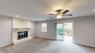 Located at 1139 Tekulve Rd in Batesville, Indiana, this two-floor home offers a well-organized layout with functional living spaces throughout. The main living area is a comfortable, carpeted room anchored by a classic brick fireplace and equipped with a ceiling fan. Sliding glass doors open directly to the outdoors, allowing natural light to fill the space and providing easy access to the backyard greenery visible beyond.

The kitchen features rich, dark cabinetry paired with light granite countertops and wood-look flooring, creating a modern contrast. A stainless steel refrigerator and ample cabinet storage complete the space.

The bedrooms are carpeted and include ceiling fans, with windows that bring in natural light. Closets offer built-in shelving and hanging rods for organized storage. Neutral gray walls throughout the home provide a clean, versatile backdrop.

The bathrooms are finished with warm, stone-look tile flooring and tiled tub surrounds. One bathroom includes a dark wood vanity with a white countertop and a framed mirror, while another is appointed with a tub-shower combination and coordinating tile work.

The home's consistent use of neutral tones, practical finishes, and thoughtful layout make it a straightforward and functional residence in a residential Batesville neighborhood.