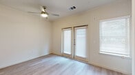 This single-story residence in Austin, Texas, offers a clean, modern aesthetic throughout its thoughtfully designed layout. Light wood-style flooring flows continuously across the space, lending a cohesive and airy feel to every room.

The living area is a welcoming space anchored by a ceiling fan with integrated lighting and French doors fitted with horizontal blinds, allowing natural light to filter in while providing privacy. An additional side window further brightens the room.

The kitchen is well-appointed with rich dark cabinetry providing ample storage, granite countertops, and a classic white subway tile backsplash. Stainless steel appliances — including a refrigerator, gas range, dishwasher, and built-in microwave — complete this functional and stylish cooking space.

A hallway connects the main living areas to the private quarters, and features a smart thermostat panel, recessed ceiling lighting, and access to additional rooms. The bedroom offers a clean, neutral canvas with high walls that enhance the sense of vertical space.

The bathroom is designed with accessibility in mind, featuring grab bars, a spacious layout with light wood-style tile flooring, a dark-framed vanity with granite countertop, and a tub-shower combination. This residence combines practicality with modern finishes in a prime Austin location.