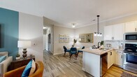 Located at 1747 Alexander Springs Ln in Wake Forest, NC, this single-floor residence offers a thoughtfully designed open-concept layout that seamlessly connects the living, dining, and kitchen areas. The living room is a standout space, featuring crown molding, wood-look flooring, a bold teal accent wall, and French doors that invite natural light and provide outdoor access. The kitchen is well-equipped with crisp white cabinetry, granite countertops, a subway tile backsplash, stainless steel appliances, a peninsula with pendant lighting, and a built-in sink — ideal for both everyday cooking and entertaining. The adjacent dining area flows naturally from the kitchen, creating a cohesive and functional common space. The primary bedroom features a ceiling fan, a two-tone accent wall, and ample room for a king-sized bed. The second bedroom continues the home's color palette with a deep navy accent wall and large windows that bring in natural light. Both bathrooms are finished with wood-look tile flooring, white vanities, and tub-shower combinations. Throughout the residence, neutral tones, crown molding, and consistent flooring choices create a clean, cohesive aesthetic that is both modern and comfortable.