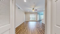 This single-story home offers a thoughtfully designed layout across 3 bedrooms and 2 bathrooms. The open living and dining areas are unified by warm hardwood flooring and elegant crown molding, with ceiling fans providing comfort throughout. Large windows flood the space with natural light, while a front-facing window in the primary living area frames outdoor views beautifully.

The dining area is a standout feature, boasting a striking bay window configuration with multiple panes that invite abundant natural light and a charming chandelier overhead. It connects seamlessly to the kitchen, which is well-equipped with white shaker cabinetry, granite countertops, a tile backsplash, stainless steel appliances, and a practical galley-style layout.

The three bedrooms are carpeted for comfort, each equipped with a ceiling fan and ample space. The generously sized primary bedroom benefits from a large window and natural light. Both bathrooms are finished to a high standard, featuring granite-topped white vanities, soaking tubs, and glass-enclosed showers with white tile surrounds and light tile flooring. Four hallways connect the home's spaces, contributing to a functional and well-organized flow throughout the residence.