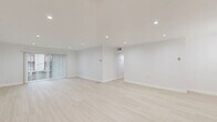Located at 2332 S Bentley Ave in West Los Angeles, this thoughtfully designed 2-bedroom, 2-bathroom residence offers a clean, modern aesthetic throughout its well-appointed single-floor layout. Light-toned hardwood flooring and crisp white walls create a bright, airy atmosphere that flows seamlessly from room to room.

The open-concept living room is generously proportioned, bathed in natural light through floor-to-ceiling vertical blinds and a sliding glass door that frames views of lush greenery outside. Recessed lighting throughout enhances the clean, contemporary feel.

The galley-style kitchen is fully equipped with stainless steel appliances, including a range, microwave, refrigerator, and dishwasher. White shaker cabinetry with matte black hardware pairs elegantly with marble-look quartz countertops, delivering both style and functionality.

Both bedrooms are well-sized, with the primary bedroom offering notable room to accommodate a full furniture arrangement. Each bedroom features recessed lighting and windows with blinds for natural light and privacy.

The two bathrooms are finished with large-format marble-look tile. One bathroom features a tiled walk-in shower, while the other includes a soaking tub with a full tile surround, a built-in niche, and matte black fixtures. Additional conveniences include three closets, a dedicated laundry area, and a connecting hallway for efficient circulation throughout the home.