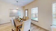 This contemporary two-story residence in Seagoville, Texas, offers 1,570 square feet of thoughtfully designed living space. The home features two bedrooms, including a generous 190 square foot primary bedroom, and two full bathrooms. The ground floor spans 660 square feet, while the upper level provides 920 square feet of space.

The interior boasts a modern aesthetic with a neutral color palette, enhanced by abundant natural light from large windows throughout. The kitchen is a standout feature, showcasing sleek wooden cabinetry, stainless steel appliances, and a spacious island with granite countertops and bar seating. Adjacent to the kitchen, a dining area with a rustic wooden table creates a seamless flow for entertaining.

An office space is brilliantly designed with contemporary furnishings, including uniquely patterned chairs and a striking abstract wall art piece. The bedrooms offer comfort and style, with ample closet space and large windows. Bathrooms are elegantly appointed with marble-look tile flooring and granite countertops.

The home's layout includes three staircases, two closets, and a combined dining room and kitchen area. Attention to detail is evident in features like the ceiling fans, modern light fixtures, and carefully chosen decor elements that contribute to the overall sophisticated ambiance of this Seagoville residence.
