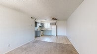 Located on W Camelback Road in Phoenix, Arizona, this single-level unit offers a practical and efficient layout across one bedroom and one bathroom. The open-plan living and kitchen area forms the heart of the unit, where light tile flooring transitions seamlessly into carpeted living space. A ceiling fan overhead provides air circulation, while a front-facing window brings in natural light and offers views of the surrounding exterior. The kitchen features gray cabinetry with ample upper and lower storage, light countertops, a double-basin sink, a freestanding electric range with overhead ventilation, and a full-size refrigerator — all finished with a tiled backsplash. The bedroom is a comfortable, carpeted space with a window fitted with vertical blinds that allow natural light to filter in. Direct access from the bedroom leads conveniently to the bathroom and closet. The bathroom includes a full-size tub and shower combination, a toilet, and tile flooring. Throughout the unit, textured ceilings and clean white walls create a consistent, neutral aesthetic. The dedicated closet provides practical storage to complement the bedroom. This straightforward, functional layout suits those seeking an efficient living space in Phoenix.