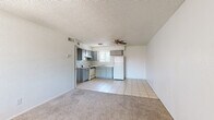 Located on W Camelback Road in Phoenix, Arizona, this single-level unit offers a practical and efficient layout across one bedroom and one bathroom. The open-plan living and kitchen area forms the heart of the unit, where light tile flooring transitions seamlessly into carpeted living space. A ceiling fan overhead provides air circulation, while a front-facing window brings in natural light and offers views of the surrounding exterior. The kitchen features gray cabinetry with ample upper and lower storage, light countertops, a double-basin sink, a freestanding electric range with overhead ventilation, and a full-size refrigerator — all finished with a tiled backsplash. The bedroom is a comfortable, carpeted space with a window fitted with vertical blinds that allow natural light to filter in. Direct access from the bedroom leads conveniently to the bathroom and closet. The bathroom includes a full-size tub and shower combination, a toilet, and tile flooring. Throughout the unit, textured ceilings and clean white walls create a consistent, neutral aesthetic. The dedicated closet provides practical storage to complement the bedroom. This straightforward, functional layout suits those seeking an efficient living space in Phoenix.