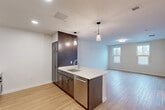Located at Walnut St & Route 140 in Foxboro, MA, this well-appointed one-bedroom, one-bathroom residence offers a thoughtfully designed single-floor layout with modern finishes throughout. Light wood-tone flooring flows seamlessly across the entire unit, contributing to a bright, cohesive aesthetic.

The open-concept kitchen and living/dining area serves as the heart of the home. The kitchen features dark espresso cabinetry, white quartz countertops, a peninsula with an undermount sink, and a full suite of stainless steel appliances including a refrigerator, electric range, built-in microwave, and dishwasher. Elegant pendant lighting over the peninsula adds a contemporary touch, while recessed ceiling lights provide additional illumination.

The combined living and dining area offers a comfortable, open feel with a window that brings in natural light and views of surrounding trees. The bedroom is a well-sized private retreat with its own window overlooking the wooded surroundings, providing a serene atmosphere. The bedroom also includes access to multiple closets, one featuring built-in shelving.

The bathroom is finished with dark cabinetry, white countertops, and includes accessibility-friendly grab bars. The unit is further complemented by a utility room, an entrance area, and ample closet storage throughout.