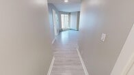 Located at 1243 11th Ave SW in Calgary, AB, this 2-bedroom, 2-bathroom unit offers a thoughtfully designed single-floor layout with a clean, contemporary aesthetic throughout. Light wood-look flooring flows consistently across all living areas, complemented by neutral warm-toned walls and crisp white baseboards that lend a bright, cohesive feel to the space.

The kitchen serves as a functional centrepiece, featuring rich wood-toned cabinetry, a white quartz countertop with an extended breakfast bar, stainless steel appliances including a refrigerator, electric range, and built-in microwave, as well as a tile backsplash and recessed pot lighting. It connects seamlessly to the open living room, which benefits from large windows and baseboard heating units along the perimeter walls.

The primary bedroom features corner windows that allow ample natural light and views of the surrounding building exterior. The second bedroom is a quiet, well-proportioned room with the same light flooring. Both bathrooms are finished consistently, each with a tub-shower combination, light tile flooring, a wood-toned vanity, and a white countertop. The hallways connecting the rooms are generously sized, contributing to the easy flow of the layout. Textured ceilings are present throughout the unit.