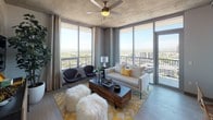 This contemporary high-rise unit showcases an industrial-modern aesthetic defined by exposed concrete ceilings, wide-plank flooring, and a refined neutral color palette throughout. The open-concept living area is a standout, featuring wraparound floor-to-ceiling windows that flood the space with natural light and frame breathtaking panoramic city and skyline views. A ceiling fan adds a functional touch to this airy, light-filled room, which opens to a private balcony. The kitchen is well-appointed with dark espresso cabinetry, stainless steel appliances including a full-size refrigerator, gas range, and built-in microwave, complemented by a dark quartz island countertop and stylish pendant lighting overhead. A white geometric tile backsplash adds texture and contrast. The primary bedroom features soft carpeting, a walk-in closet with built-in shelving, and an en-suite bathroom with a walk-in glass shower, dark wood vanity, and undermount sink. A second bedroom also offers carpeted floors, city views through a large window, and access to a full bathroom complete with a soaking tub and white subway tile surround. Throughout the unit, thoughtful finishes and elevated design details create a cohesive and sophisticated living environment.