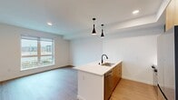 This contemporary 1-bedroom apartment in Redmond, WA offers 520 square feet of efficiently designed living space. The open-concept layout seamlessly blends the living room and kitchen, creating a spacious feel. Large windows flood the area with natural light and provide city views, enhancing the sense of openness.

The sleek kitchen boasts modern appliances, including a stainless steel refrigerator and built-in microwave. White quartz countertops contrast beautifully with the wood-toned cabinetry, while pendant lighting adds a stylish touch. The living area features wood-look flooring and ample space for furniture arrangement.

The bedroom, measuring 120 square feet, includes a ceiling fan and continues the wood flooring theme. A generous closet with double doors provides storage space. The bathroom showcases a contemporary design with a large vanity, wood cabinets, and a combination tub-shower with elegant black fixtures.

Throughout the apartment, clean white walls and minimal design elements create a fresh, modern aesthetic. The property's location at 16855 Redmond Way places residents in the heart of Redmond, offering urban convenience in a compact, well-designed living space.