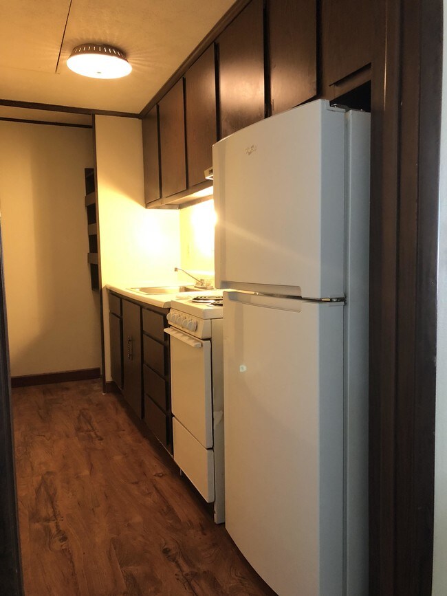 Cocina estrecha con despensa - Pinewood Court Apartments