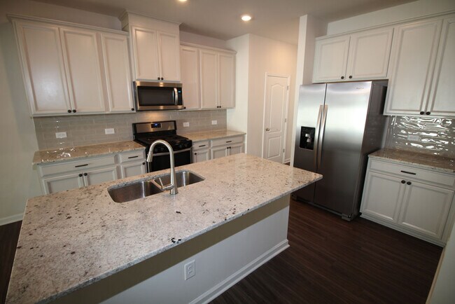 Kitchen features large island, granite counters, tile backsplash, 42 inch cabinets, gas range & upsc - 3406 Dropseed Dr